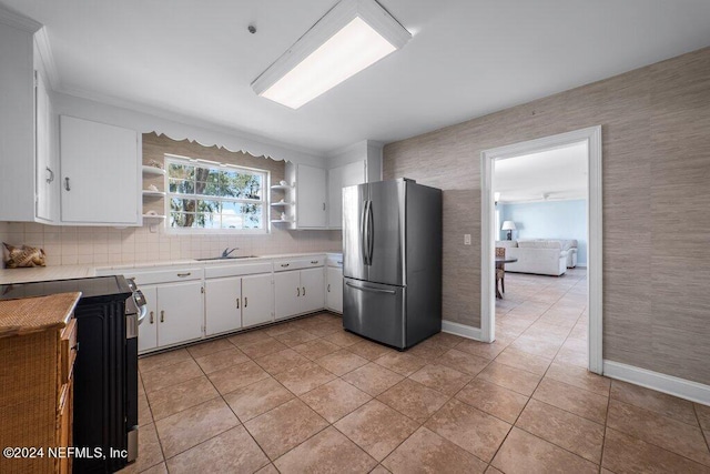 kitchen featuring open shelves, freestanding refrigerator, a sink, light countertops, and white cabinets