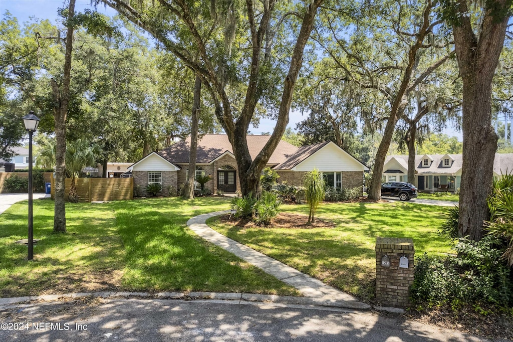 single story home featuring a front lawn