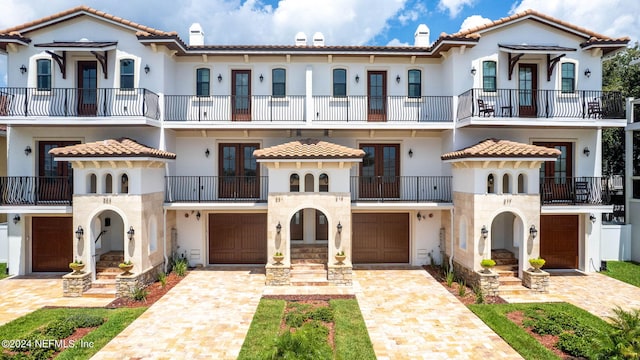 mediterranean / spanish-style home with a garage and a balcony