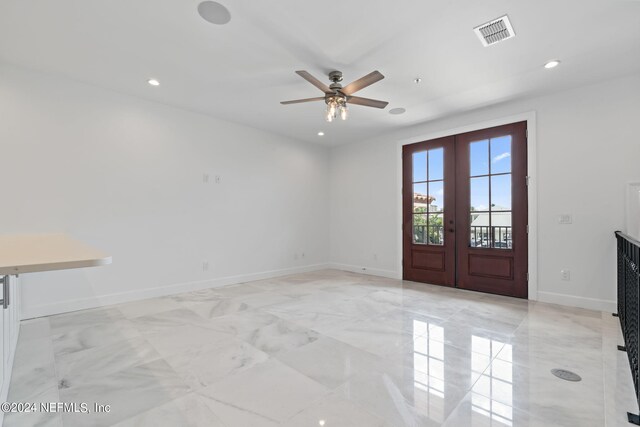 spare room with ceiling fan and french doors