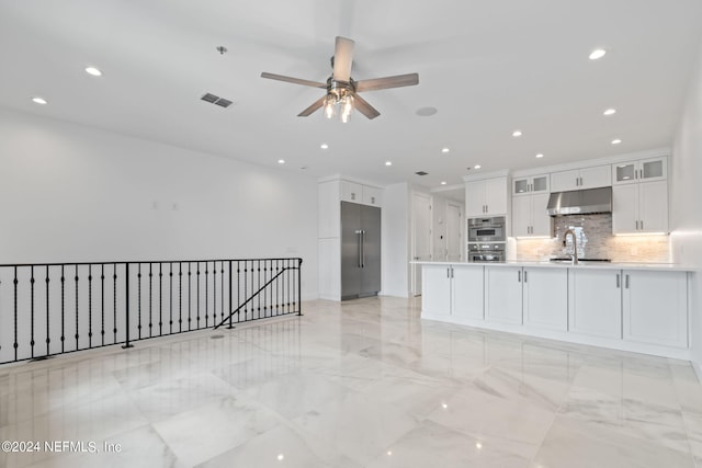 kitchen featuring appliances with stainless steel finishes, white cabinets, ceiling fan, and backsplash