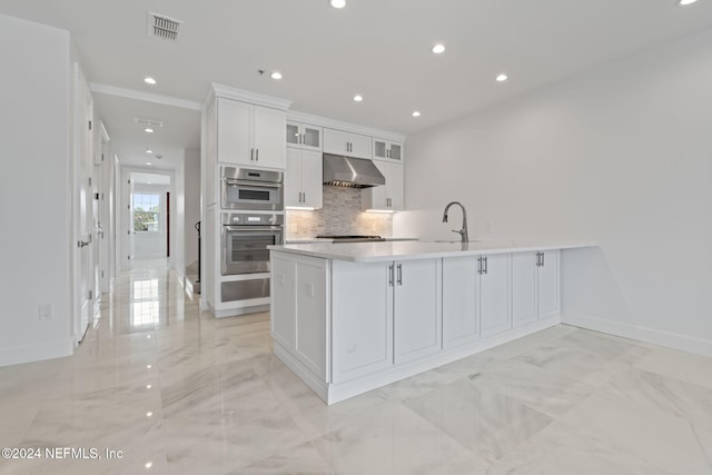 kitchen with tasteful backsplash, kitchen peninsula, sink, white cabinetry, and double oven