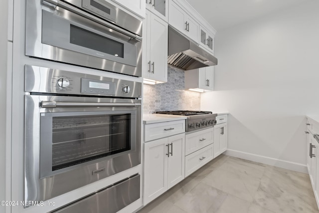 kitchen with stainless steel appliances, decorative backsplash, and white cabinetry