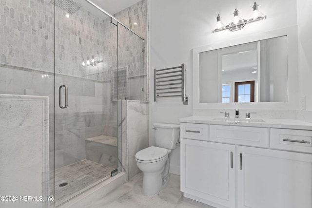 bathroom with a shower with shower door, toilet, and vanity