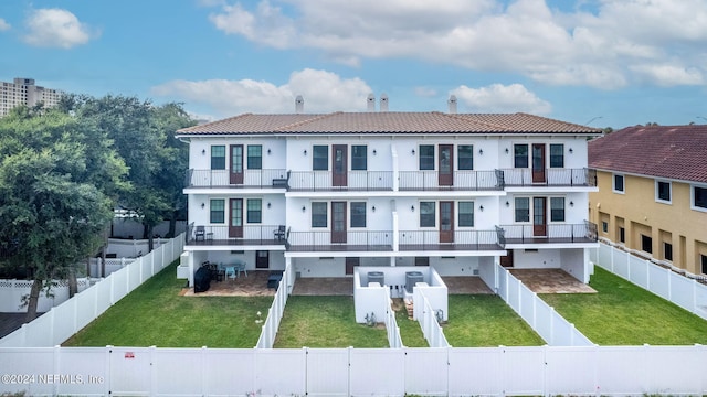 back of property featuring a lawn and a balcony