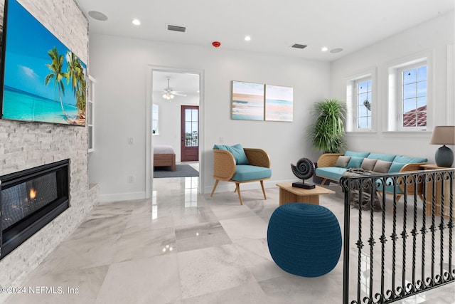 living room featuring a fireplace, a wealth of natural light, and ceiling fan