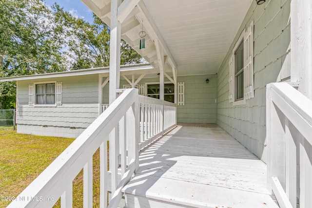 wooden deck featuring a lawn