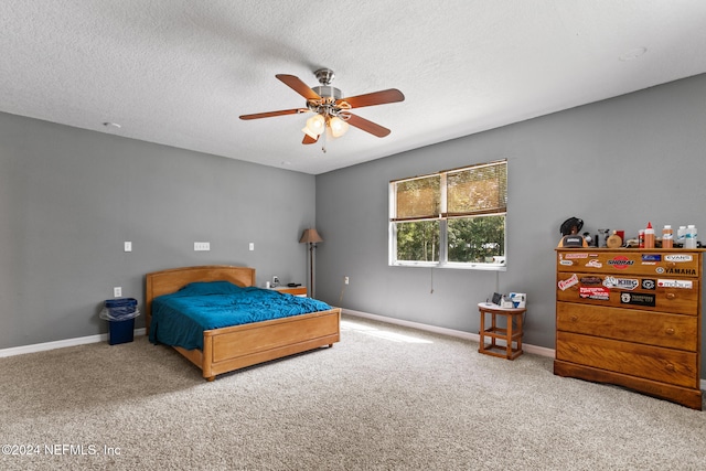 bedroom with ceiling fan, a textured ceiling, and carpet