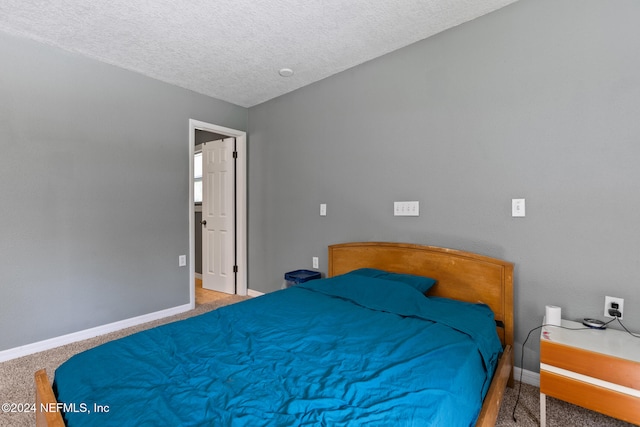 bedroom with a textured ceiling and carpet flooring