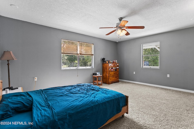 carpeted bedroom with a textured ceiling and ceiling fan