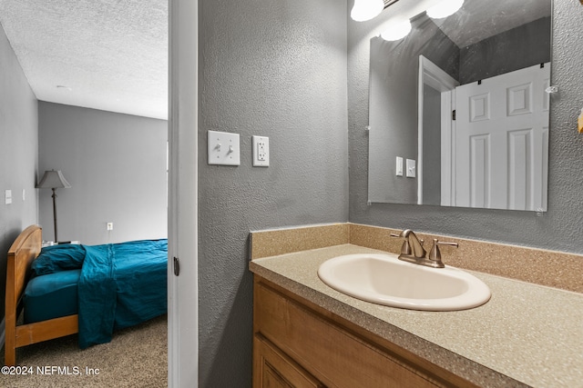 bathroom featuring a textured ceiling and vanity