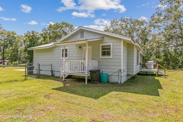 rear view of house featuring a yard