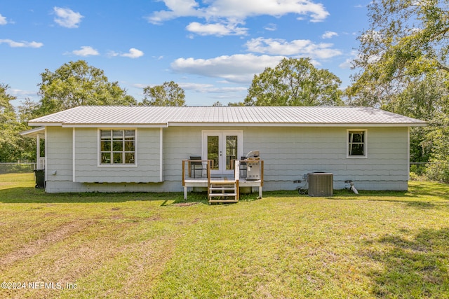 back of property with a deck, french doors, and a lawn