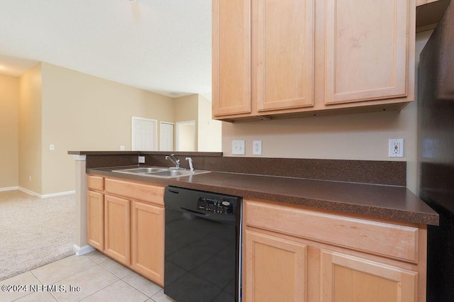 kitchen featuring dishwasher, light brown cabinetry, dark countertops, and a sink