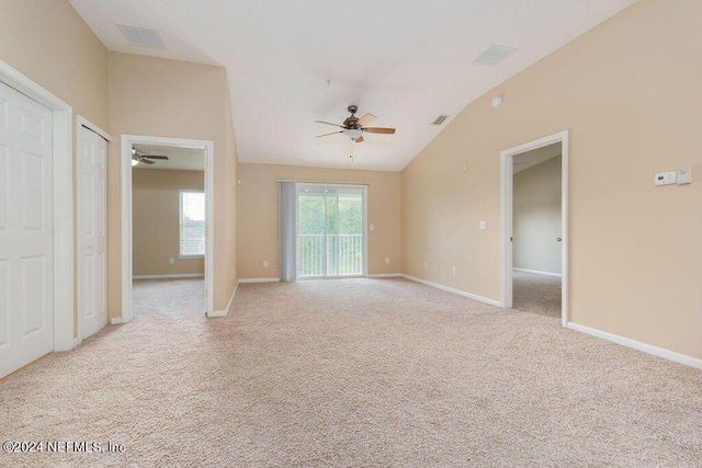 unfurnished room with ceiling fan, lofted ceiling, light carpet, visible vents, and baseboards