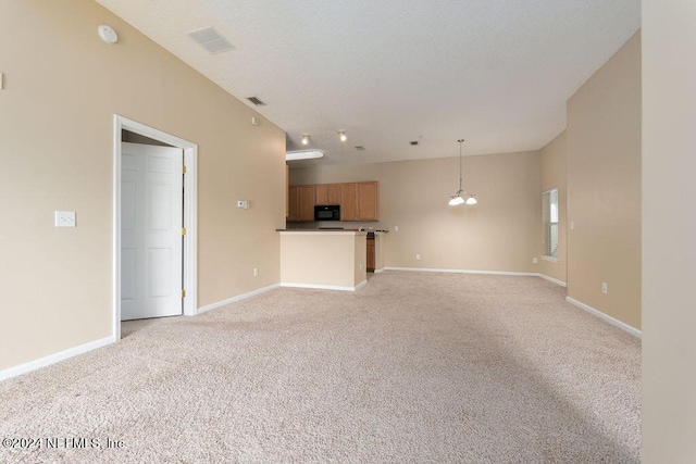 unfurnished living room featuring baseboards, a notable chandelier, visible vents, and light colored carpet