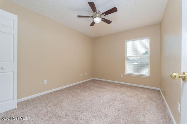 unfurnished room with baseboards, a textured ceiling, and light colored carpet