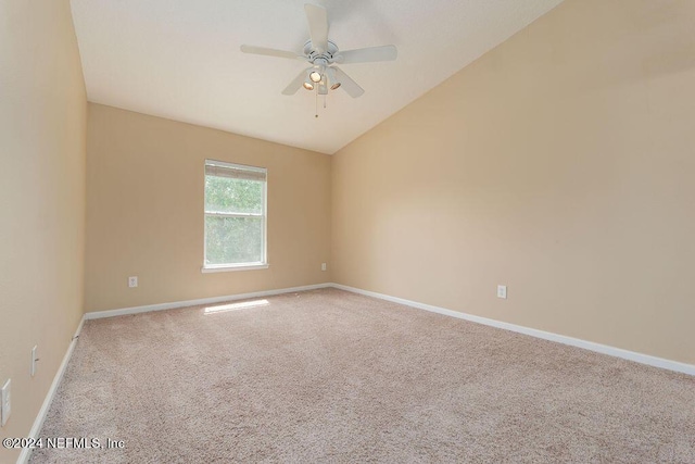 unfurnished room with light carpet, vaulted ceiling, a ceiling fan, and baseboards