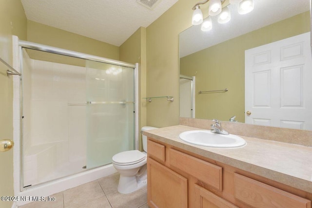 full bathroom featuring toilet, visible vents, vanity, a shower stall, and tile patterned floors