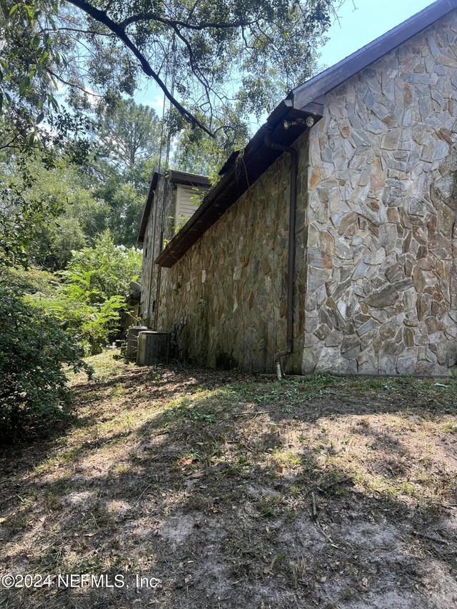 view of side of home with central air condition unit