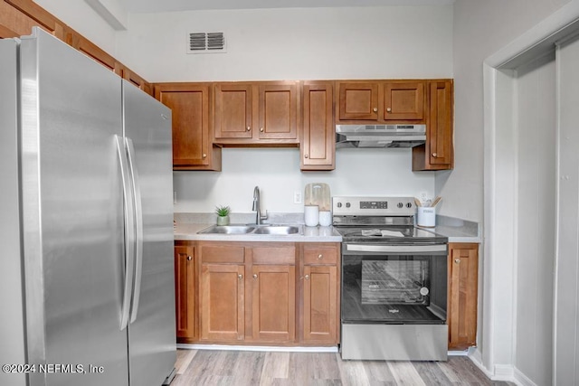 kitchen with stainless steel appliances, sink, and light wood-type flooring