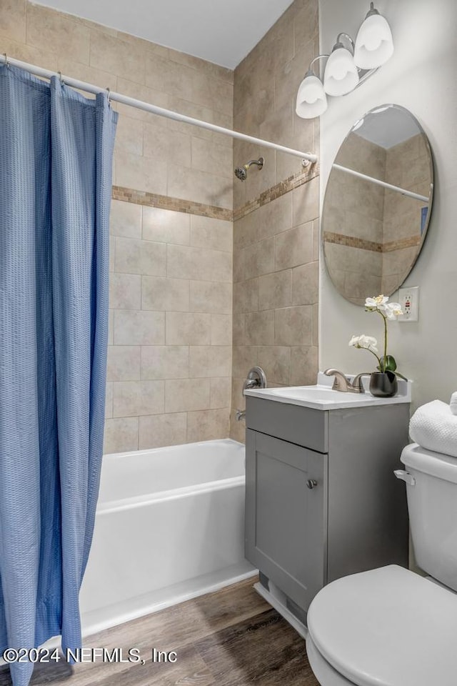 full bathroom with vanity, toilet, wood-type flooring, and shower / bath combo with shower curtain