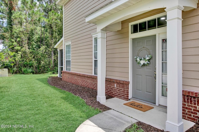 entrance to property with a lawn