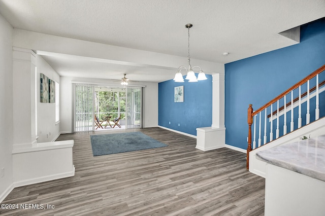 living room with a textured ceiling, ceiling fan with notable chandelier, and wood-type flooring