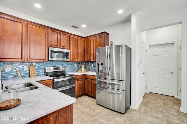 kitchen featuring backsplash, stainless steel appliances, sink, a textured ceiling, and light tile patterned floors