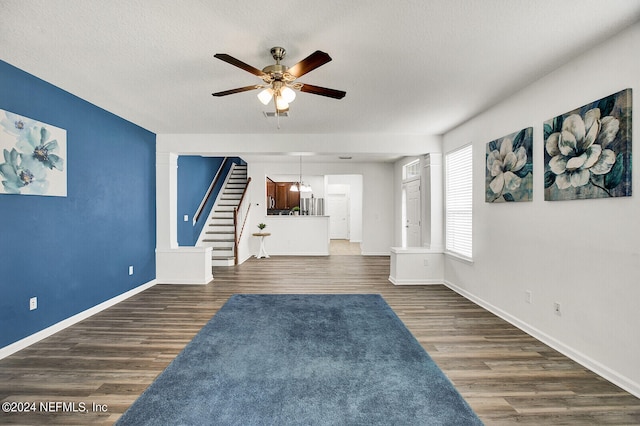 unfurnished living room featuring a textured ceiling, ceiling fan, and wood-type flooring