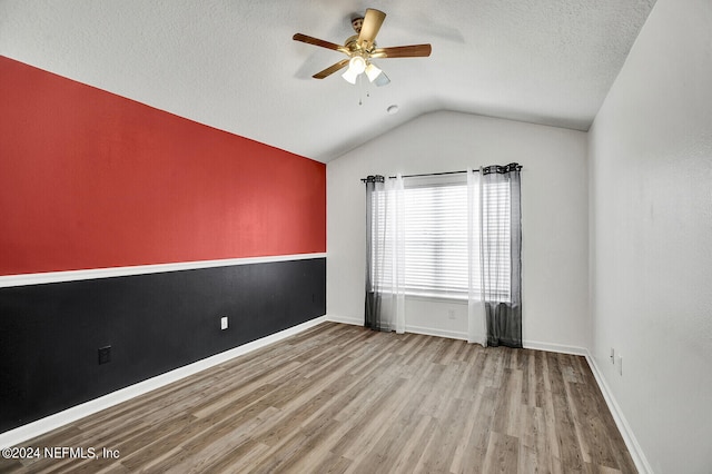 unfurnished room with ceiling fan, hardwood / wood-style flooring, a textured ceiling, and lofted ceiling