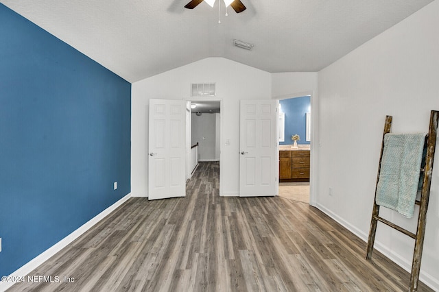 unfurnished bedroom featuring ceiling fan, vaulted ceiling, and hardwood / wood-style floors