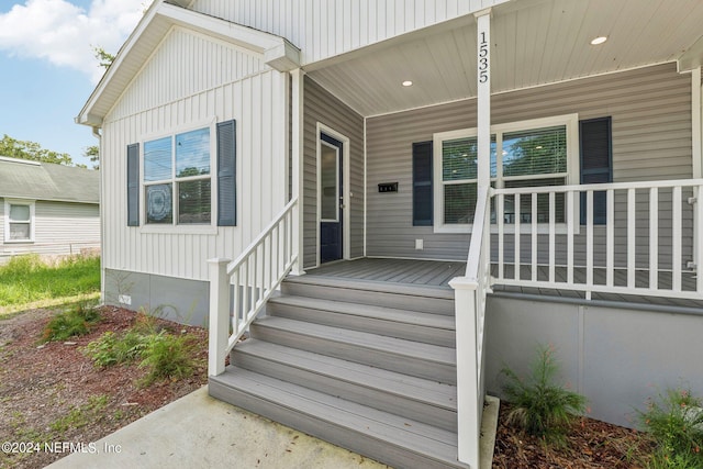 entrance to property featuring covered porch and crawl space