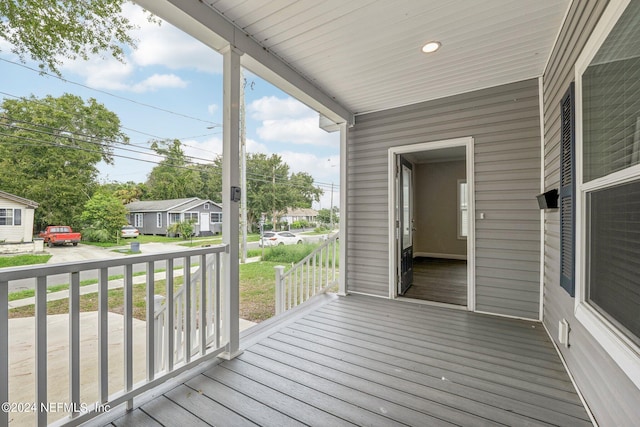wooden deck with covered porch and a residential view
