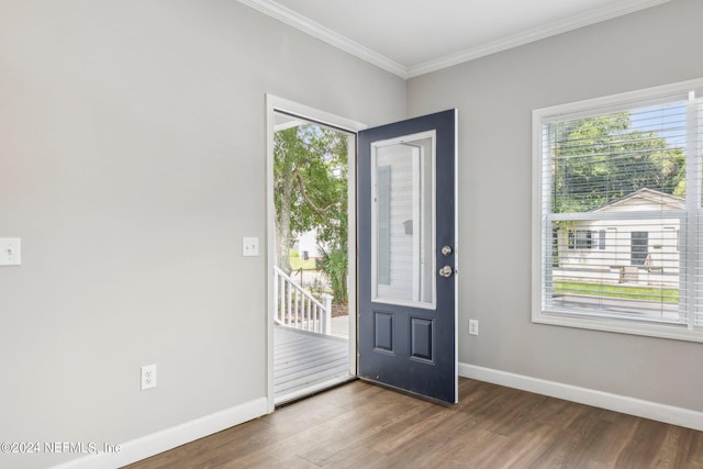foyer entrance with baseboards, wood finished floors, and ornamental molding
