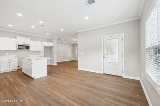 kitchen featuring stainless steel microwave, wood finished floors, a healthy amount of sunlight, and visible vents