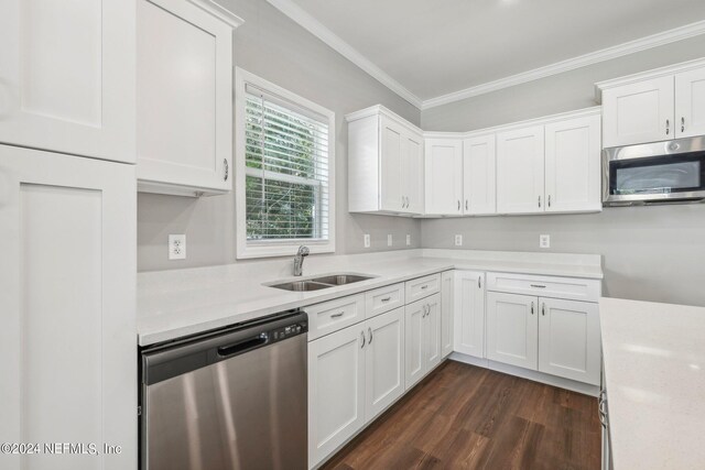 kitchen featuring light countertops, a sink, ornamental molding, and appliances with stainless steel finishes