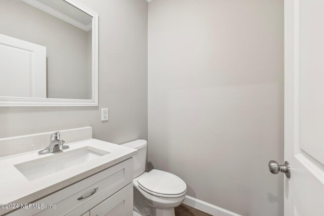 bathroom with baseboards, toilet, and vanity