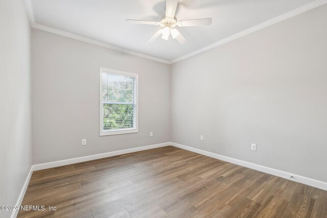 spare room featuring baseboards, crown molding, wood finished floors, and ceiling fan