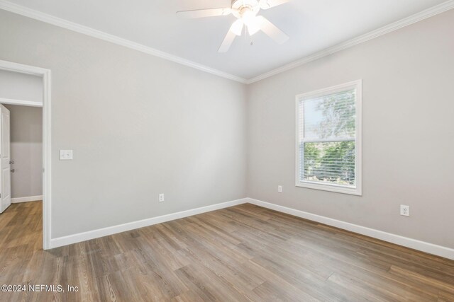 spare room featuring baseboards, ornamental molding, wood finished floors, and ceiling fan