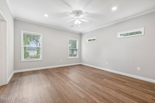 spare room with a ceiling fan, ornamental molding, baseboards, and wood finished floors