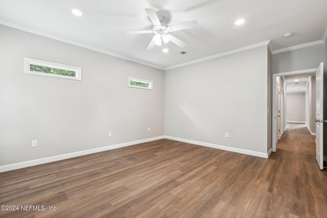 empty room with baseboards, crown molding, and wood finished floors