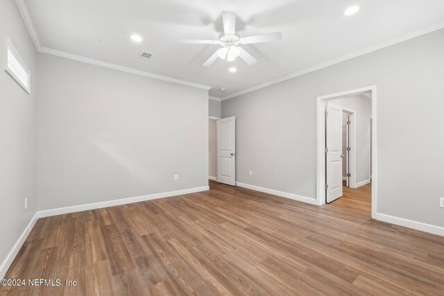 empty room featuring baseboards, crown molding, wood finished floors, and ceiling fan