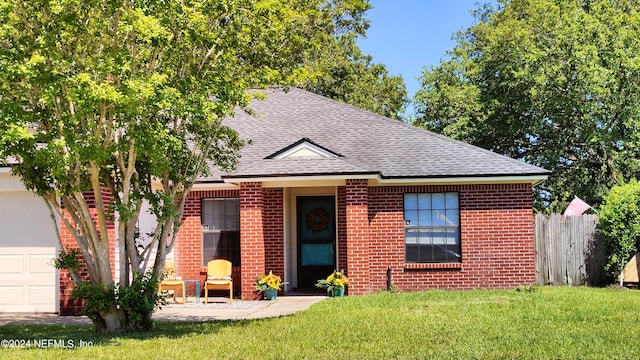 view of front of property featuring a garage and a front lawn