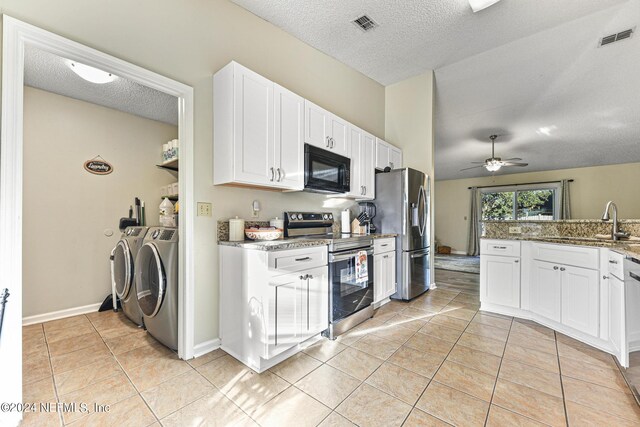 kitchen featuring sink, appliances with stainless steel finishes, stone counters, washing machine and clothes dryer, and ceiling fan