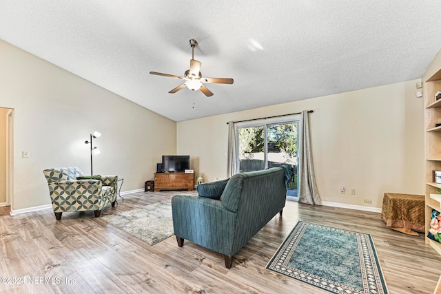 living room with ceiling fan, hardwood / wood-style flooring, a textured ceiling, and lofted ceiling