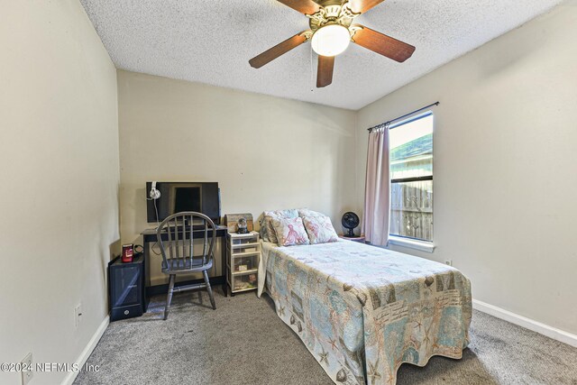 carpeted bedroom featuring ceiling fan and a textured ceiling