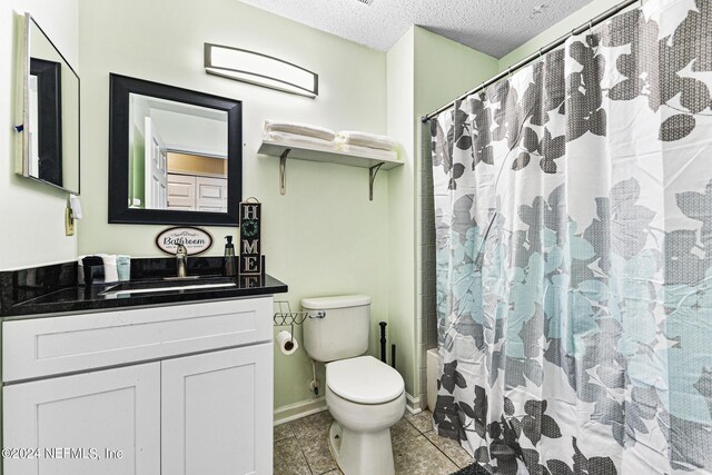 bathroom featuring a textured ceiling, toilet, vanity, and tile patterned floors