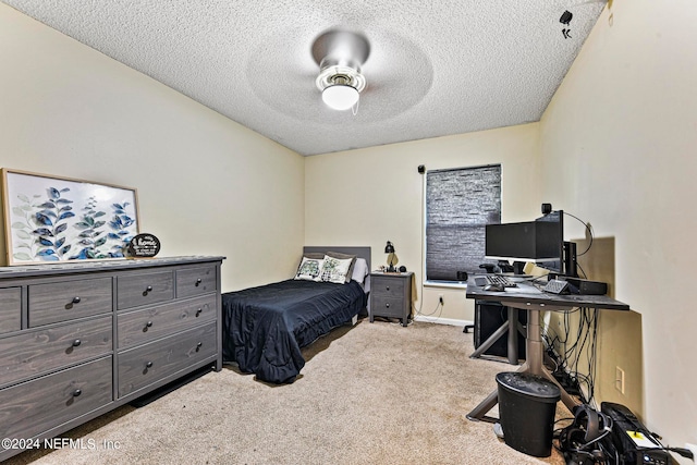 carpeted bedroom with ceiling fan and a textured ceiling