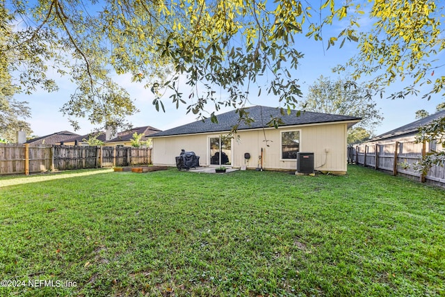 back of house featuring a lawn and central air condition unit